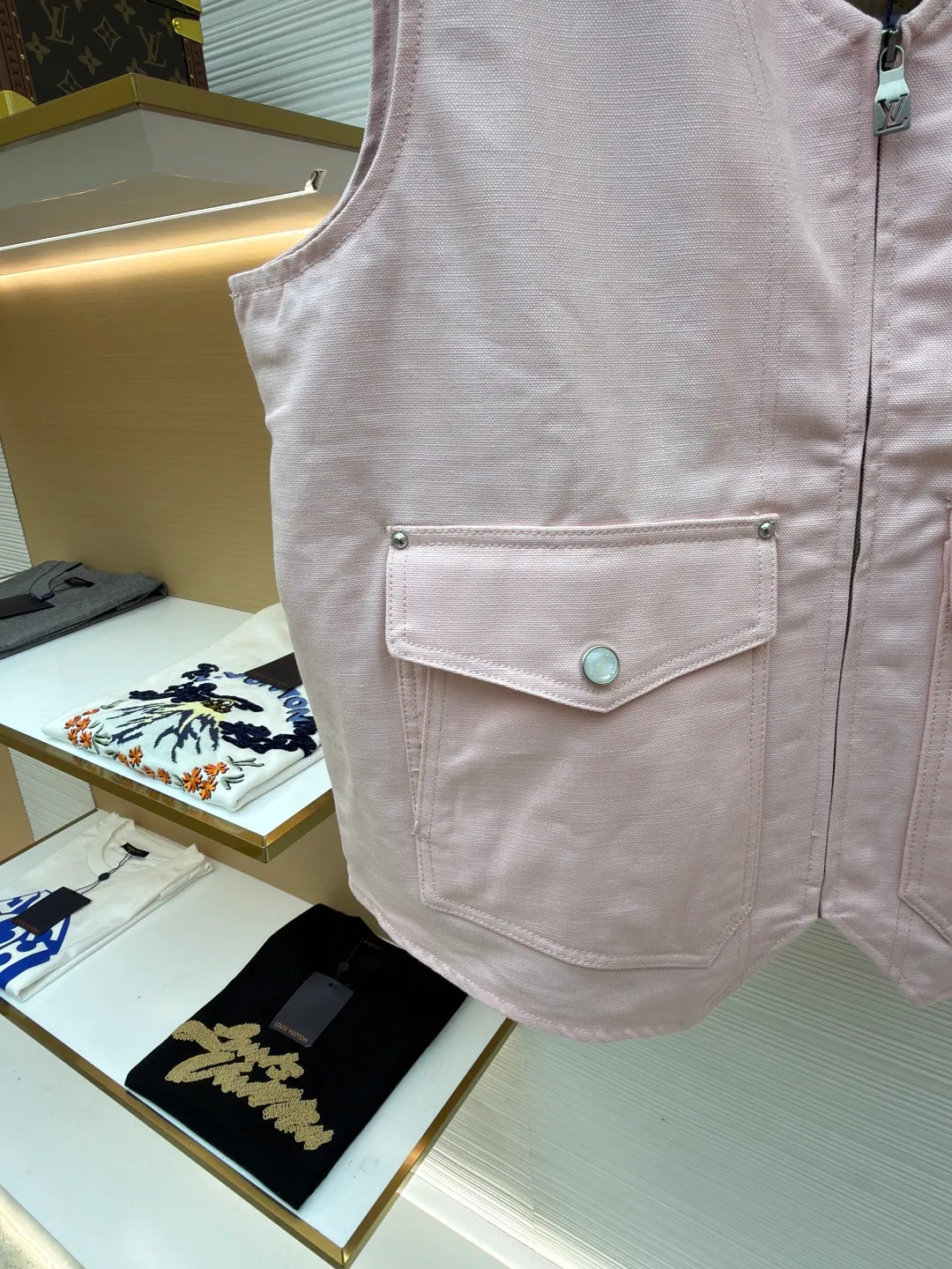 LOUIS Vuitton ●Description: This vest is made of high-quality cotton and linen blended fabrics, and the main tone of pink gives it a soft and fashionable feel. It has a V-neck design and a metal zipper placket, which is smooth and has industrial style details. The double patch pockets on the front chest have a three-dimensional structure, and the pockets are double-fastened with metal rivets and buttons to enhance practicality and decoration. A brand leather label is also embellished on the bottom of the bag to enhance recognition. The interior is quilted and the cotton batting is evenly distributed to ensure warmth and avoid clumping. The seams of the body are made of flat stitching + hemming technology, and the stitching is neat and firm, demonstrating exquisite workmanship. The overall shape is loose and moderate, combining the toughness of work clothes with the casualness of daily wear. From fabric selection to detail sewing, every craftsmanship takes into account both style expression and wearing experience. The overall wiring is straight and delicate, the fabric is comfortable and soft, and the color is consistent without color difference. It can be matched with the same style to create a fashionable look and control various occasions. Customized accessories, complete with three standards, same style for men and women!